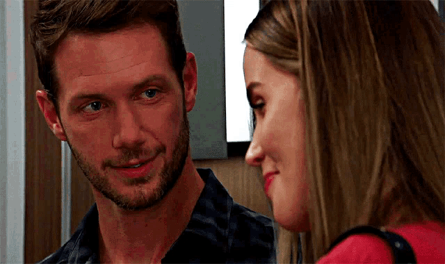 a man and a woman are looking at each other in a room .