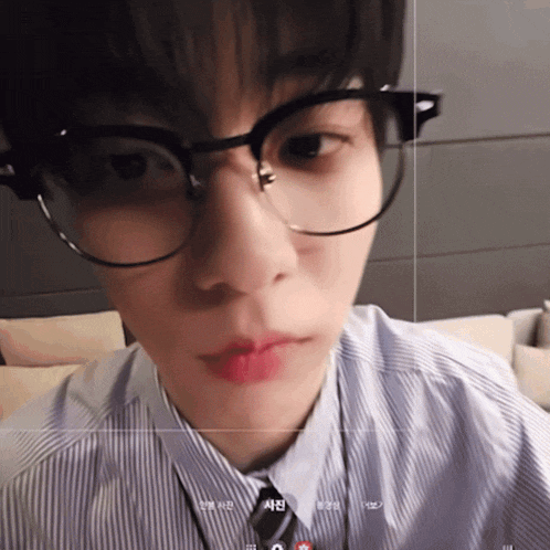 a close up of a person 's face with glasses and a tie