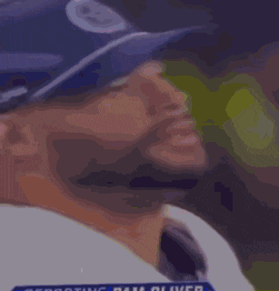 a close up of a man wearing a baseball cap and a white shirt