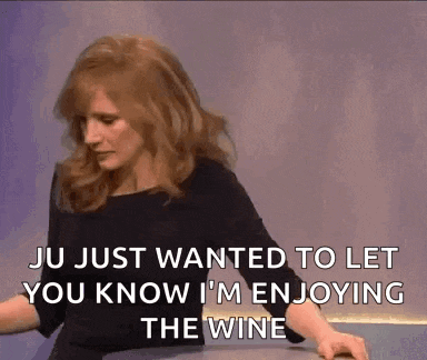 a woman is sitting at a table and saying ju just wanted to let you know i m enjoying the wine