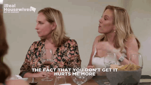 two women are sitting at a table with wine glasses and one of them says the fact that you don 't get it