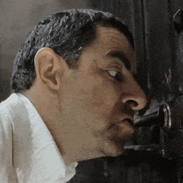 a close up of a man looking through a door