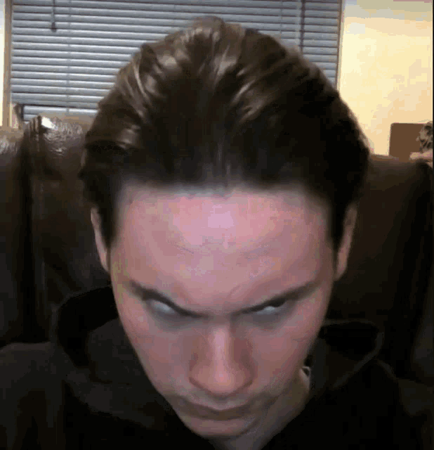 a close up of a man 's face with a serious look on his face