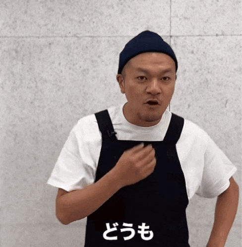 a man wearing a black apron and a white t-shirt with chinese writing