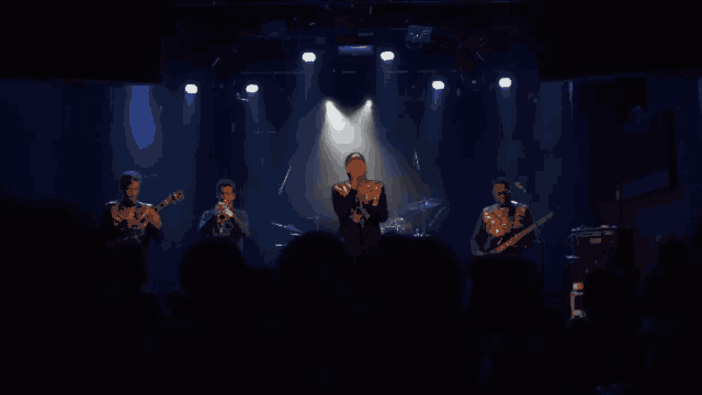 a group of men are playing instruments on a stage in front of a crowd