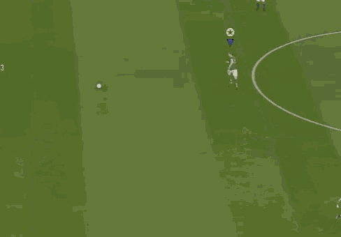 a soccer game is being played on a green field with a purple triangle in the middle