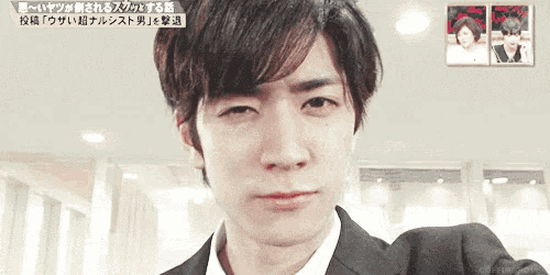 a man in a suit and white shirt is making a funny face .