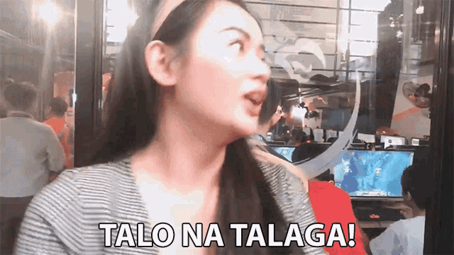 a woman says talo na talaga in front of a crowd of people