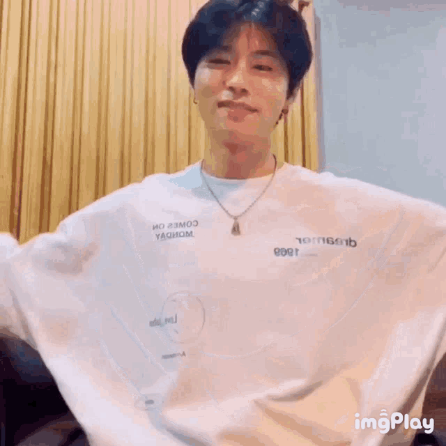 a man wearing a white t-shirt that says imgplay on the bottom