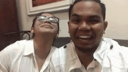 a man and a woman are sitting next to each other on a couch .