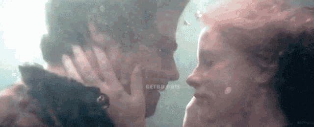 a man and a woman are kissing underwater in the water .