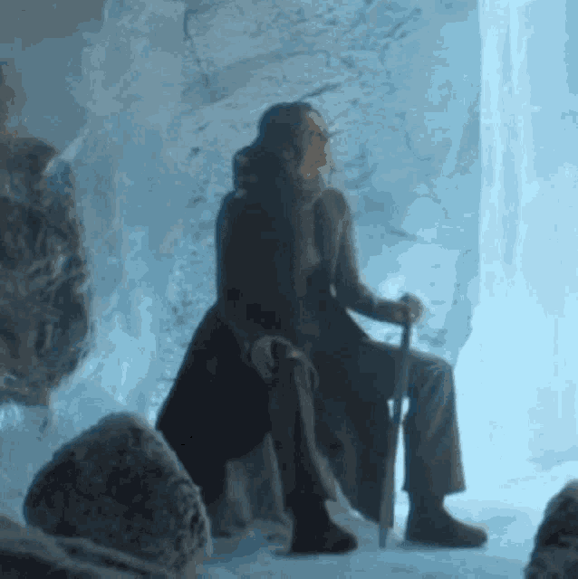 a man with a cane sits in a cave