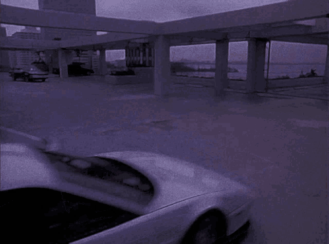 a white car is parked in a parking lot with a sign that says ' motel ' on it