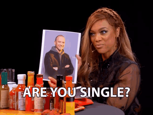 a woman holding a picture of a man and the words are you single below her