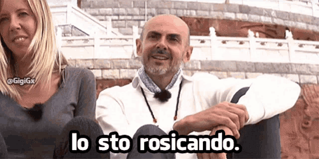 a man and a woman are sitting next to each other and the man is smiling and says lo sto rosicando