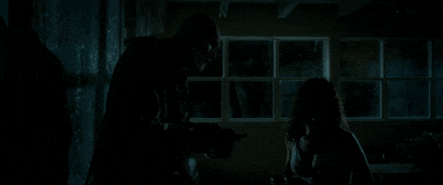 a person standing in a dark room with a gun