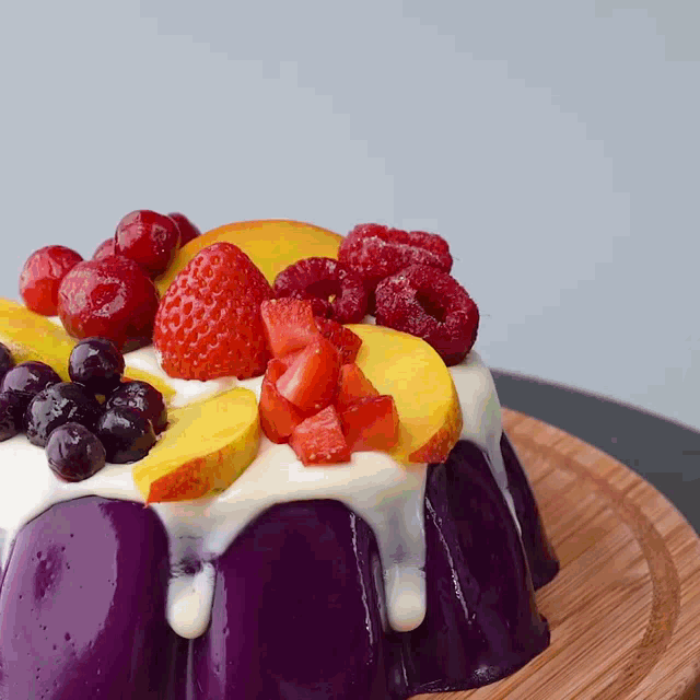 a purple cake with fruit on top of it