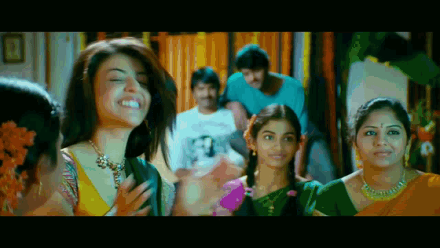 a woman in a yellow top is smiling in front of a crowd of people