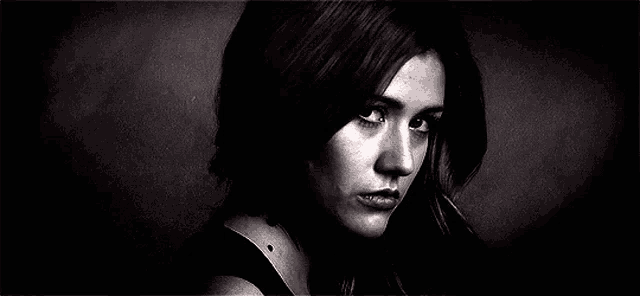 a black and white photo of a woman 's face with a serious look on her face .