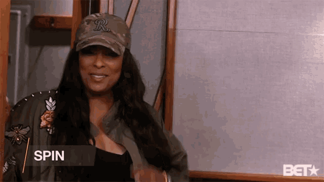 a woman wearing a hat with the letter r on it is smiling