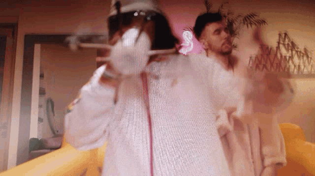 a man and a woman are dancing in front of a pink sign that says ' s ' on it