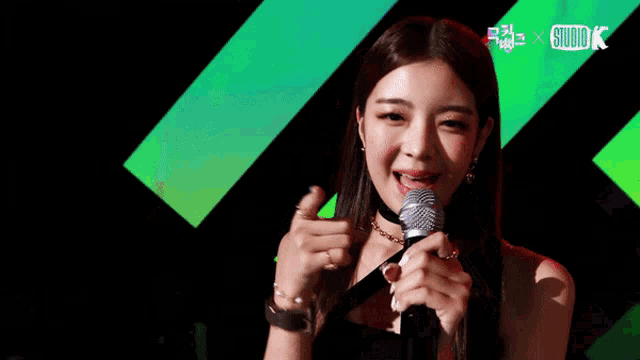 a woman singing into a microphone with a studio k logo in the corner