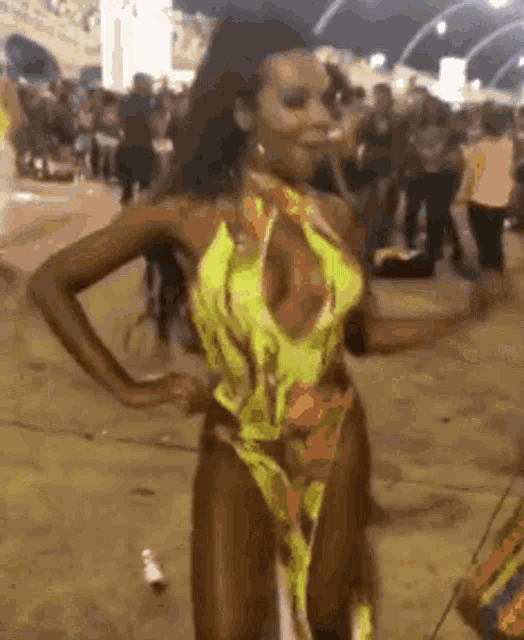 a woman in a bikini is dancing in front of a crowd .