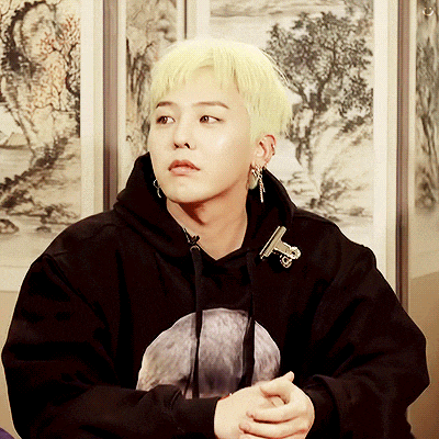 a young man with blonde hair is wearing a black sweatshirt