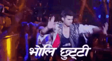 a man is dancing in front of a crowd with a sign in a foreign language