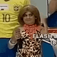 a woman in a leopard print dress is standing next to a soccer player in a yellow shirt .