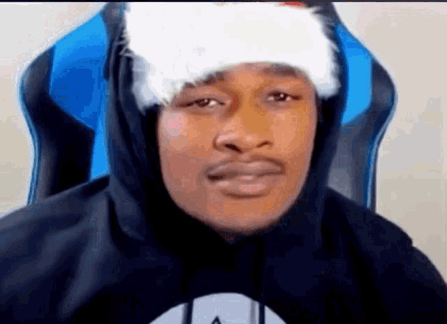 the man is wearing a santa hat and a hoodie .