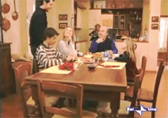 a group of people sitting at a table with a sign that says rai