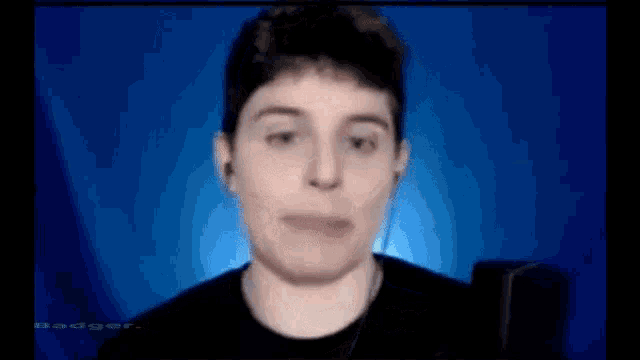 a man wearing headphones is making a funny face in front of a microphone .