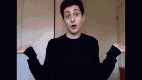 a young man in a black sweater is making a funny face .