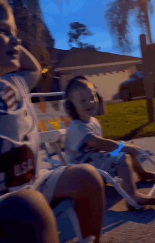 a person wearing a usa shirt sits next to a little boy