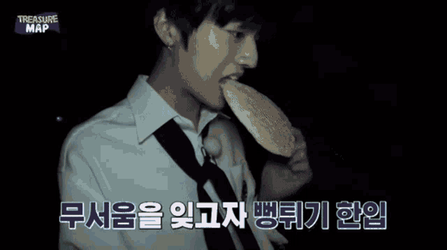 a man in a white shirt and tie is standing in the dark and looking at something .