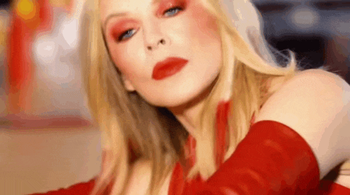 the woman is wearing red gloves and red lipstick .