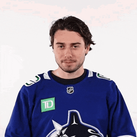 a man wearing a blue td hockey jersey looks at the camera