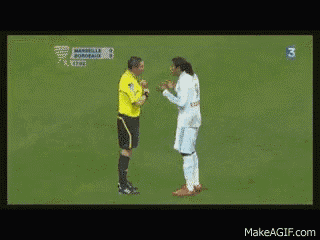 a man in a white shirt is talking to another man in a yellow shirt with the number 3 on the bottom right