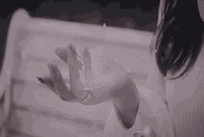 a woman is sitting on a bench with her hand outstretched .