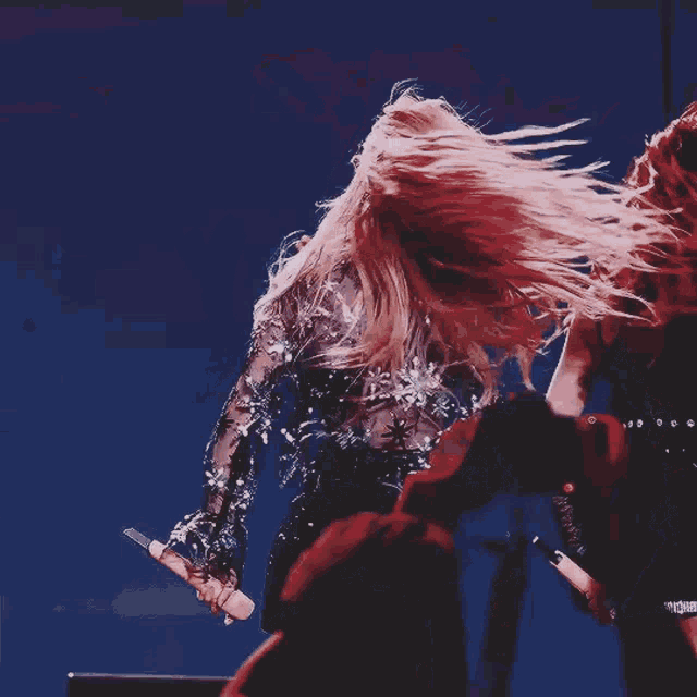 a woman with long blonde hair is dancing on a stage .