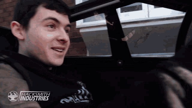 a man wearing a black shirt that says hacksmith industries on it