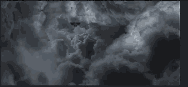 a black and white photo of a cloudy sky with the letter t in the middle