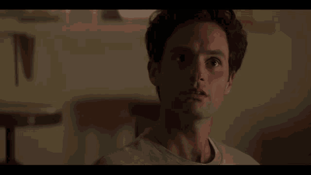 a close up of a man 's face in a room looking at something .
