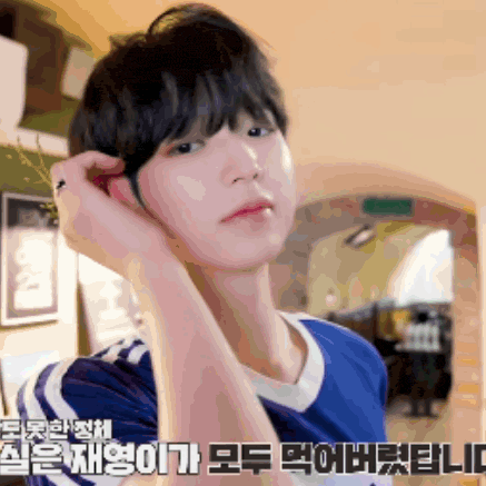 a man in a blue shirt is adjusting his hair