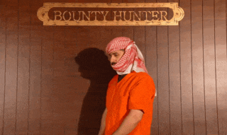 a man in a prison uniform stands in front of a sign that says bounty hunter