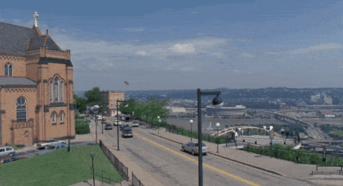 two cars are driving down a hill in front of a city skyline