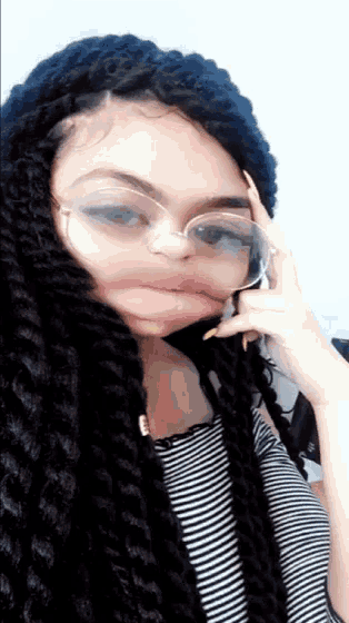 a girl with braids and glasses is making a face