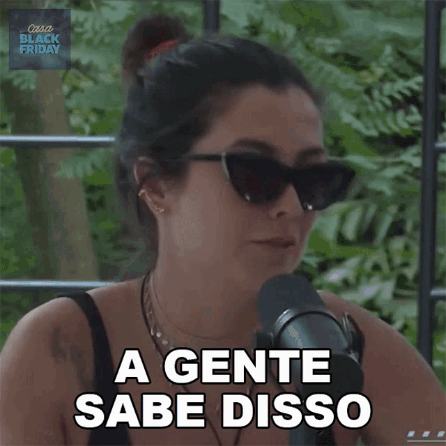 a woman wearing sunglasses talks into a microphone and says " a gente sabe disso "