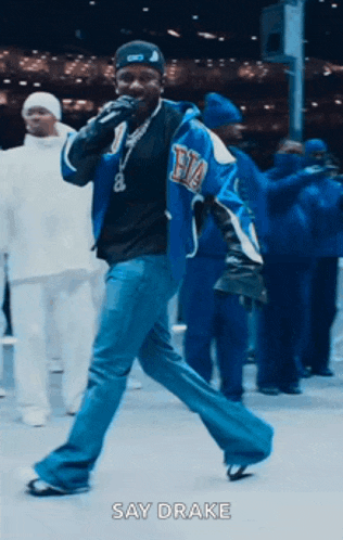 a man singing into a microphone with the words say drake behind him